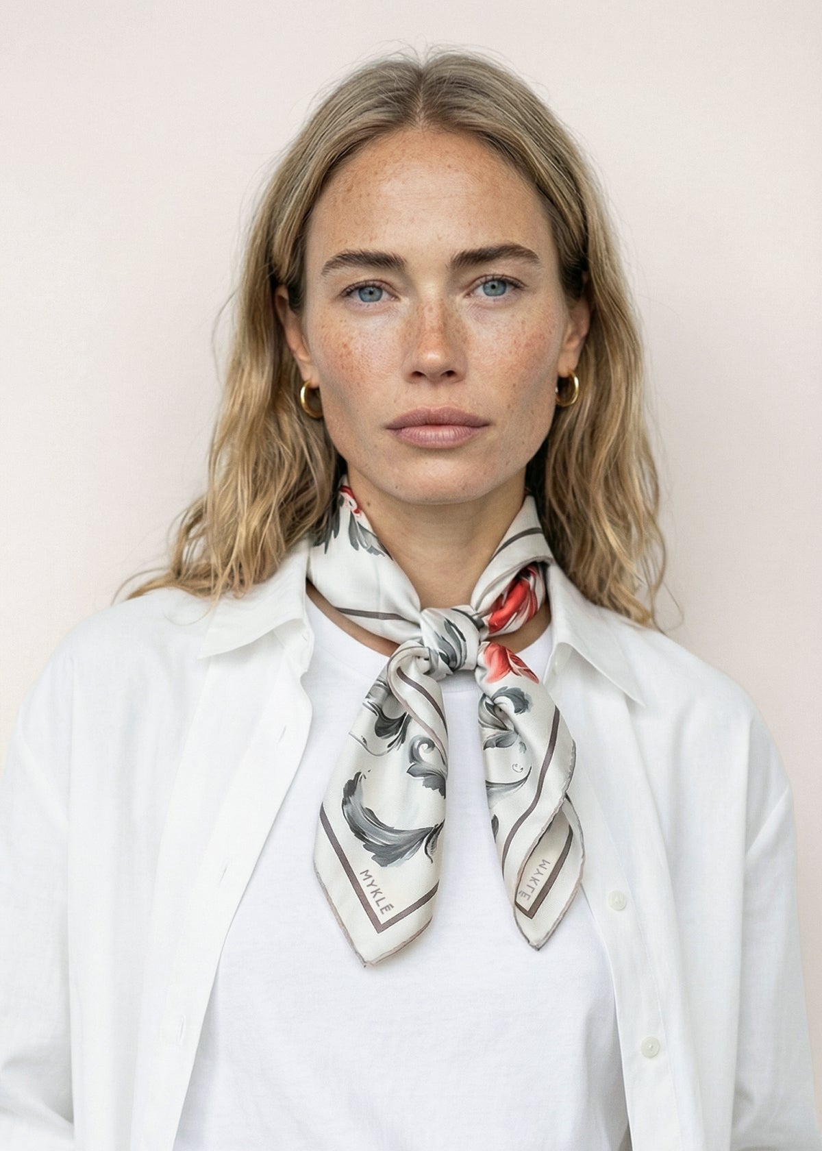 Model wearing the Kystrose silk twill scarf tied at the neck with a white shirt