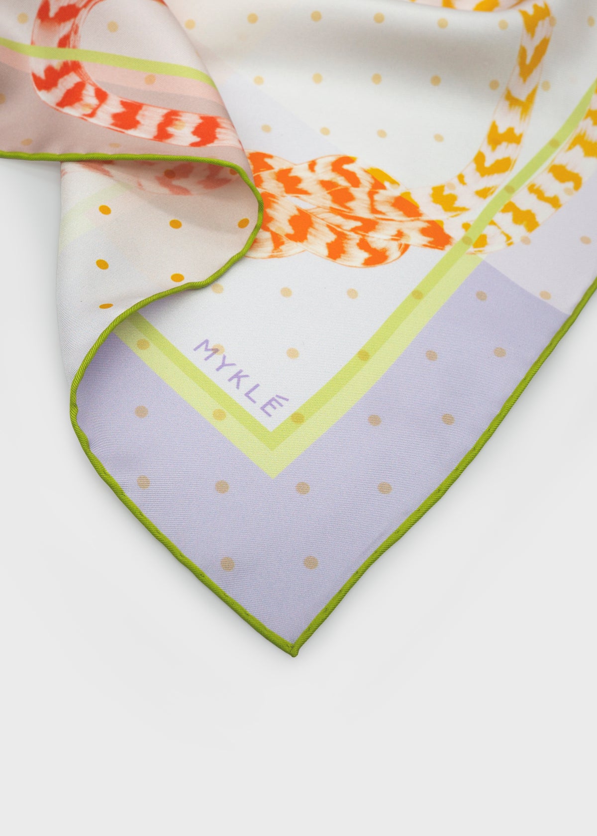 Close-up of the orange and yellow rope print and hand-rolled edge on the Ropes Entwine Sunburst silk twill scarf